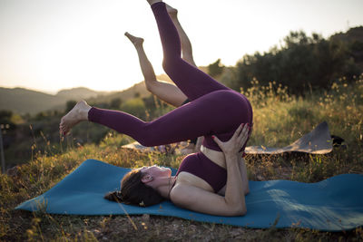 Women exercising on mats against clear sky at sunset