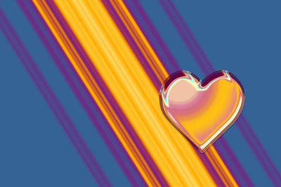 Low angle view of illuminated heart shape against blue sky