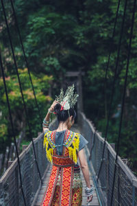 Rear view of woman standing against railing