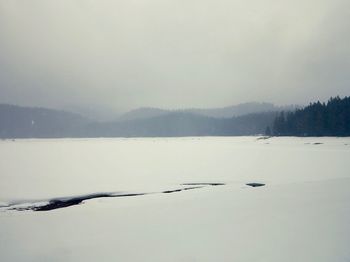 Frozen lake against sky during winter