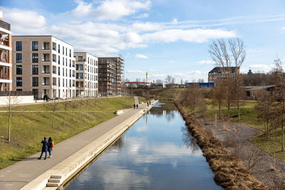 Canal amidst buildings against sky in city