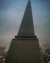 Low angle view of tower against cloudy sky