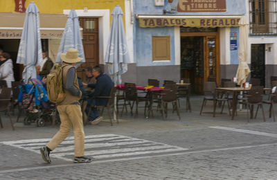 People on street against building in city