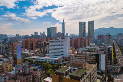 Aerial view of buildings in city against sky