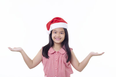 Portrait of smiling girl standing against white background