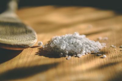 Close-up of salt with wooden spoon on table