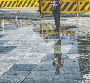 Low section of man walking on zebra crossing in city