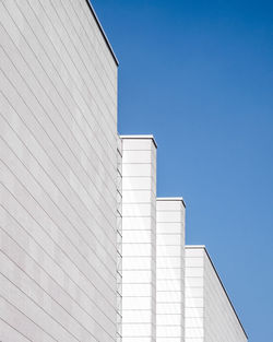 Low angle view of modern buildings against clear blue sky