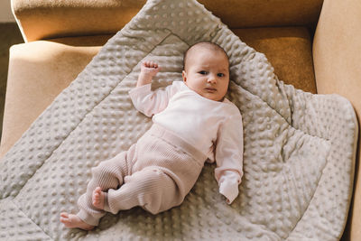 Portrait of a 1 month old baby. cute newborn baby lying on a developing rug.