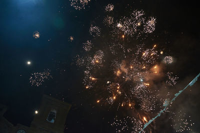 Low angle view of firework display at night