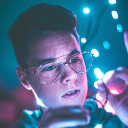 Close-up of man holding illuminated string light