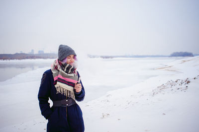 Full length of man photographing while standing on snow covered landscape