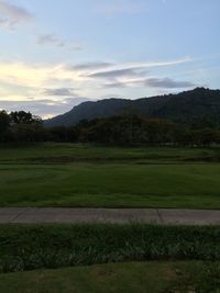 Scenic view of grassy field against cloudy sky