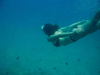 Woman wearing bikini swimming underwater