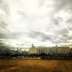 Cityscape against cloudy sky