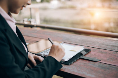 Midsection of man using mobile phone on table