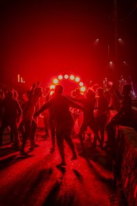 Men dancing during event in city at night