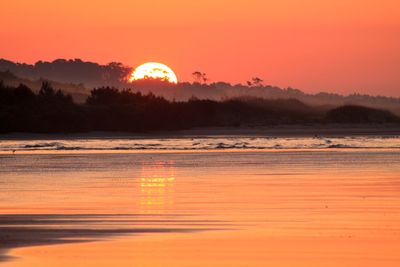 Scenic view of calm lake at sunset