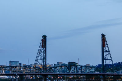 Cranes at pier against sky