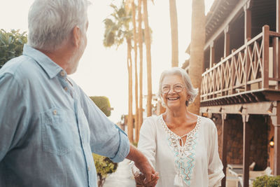 Side view of couple standing against wall