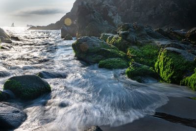 Scenic view of rocks in sea against sky