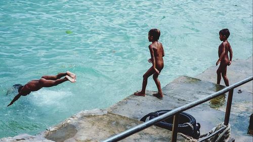 High angle view of friends enjoying in swimming pool