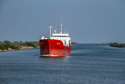 Boat sailing in sea against clear sky