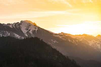 Scenic view of snowcapped mountains against sky during sunset