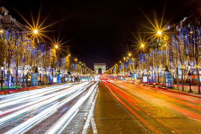 Illuminated avenue des champs-elysees and arc de triomphe at night