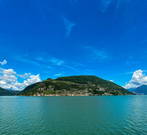 Scenic view of sea and mountains against blue sky