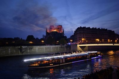 Notre-dame on fire and a bateau-mouche