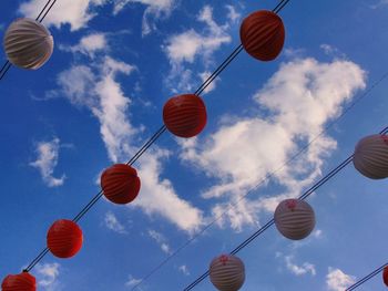 Low angle view of lanterns hanging against sky