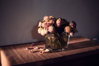 Dry roses in vase on table at home