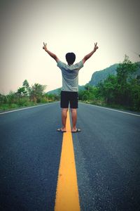 Rear view of man standing on road