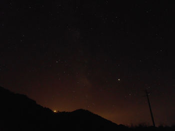 Low angle view of silhouette mountain against sky at night