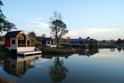 Buildings by lake against sky in city