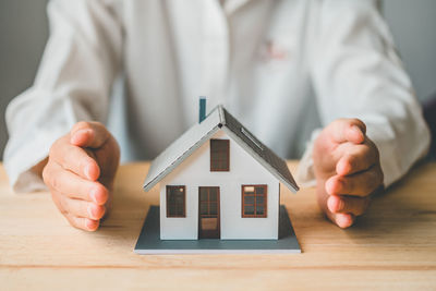 Midsection of businessman giving model house key