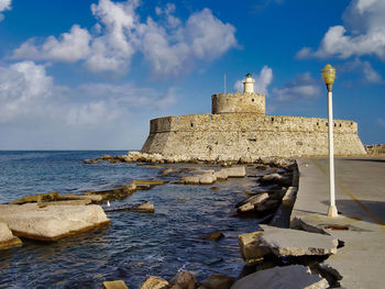 Historic building by sea against sky
