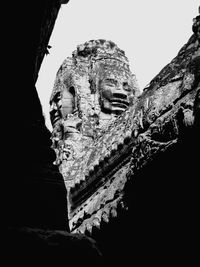 Low angle view of old statue against sky