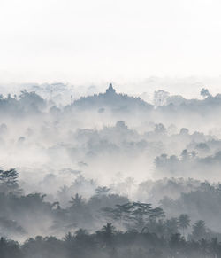 Scenic view of trees and mountains against sky