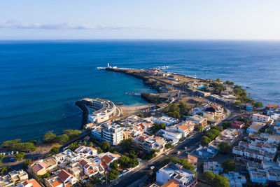 High angle view of buildings by sea against sky