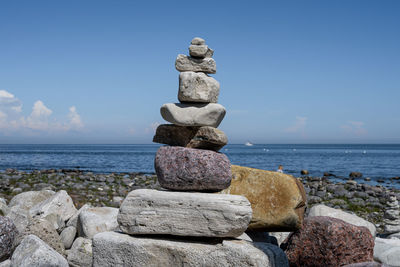 Stack of stones on beach against sky