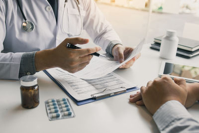 Midsection of doctor examining patient in office