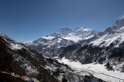 Scenic view of snowcapped mountains against clear blue sky