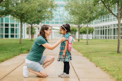 Young millennial mother sending daughter off back to school