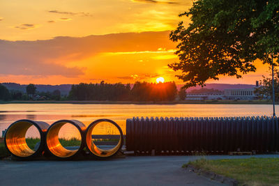 Bicycle parked on field against sky during sunset