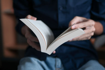 Midsection of man reading book