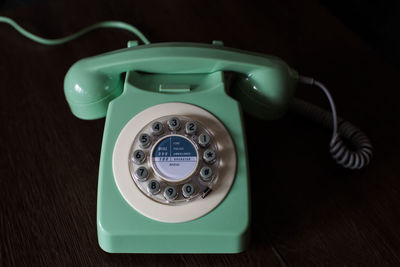 High angle view of rotary phone on wooden table