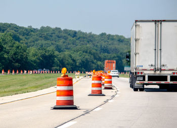 Vehicles travel the usa highways as orange construction cones pop up all over, as road repairs begin