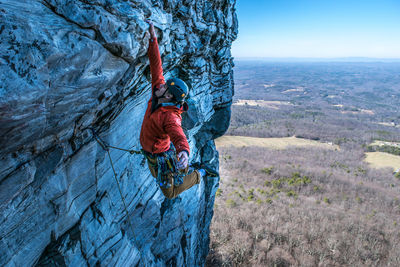 Man rock climbing against landscape